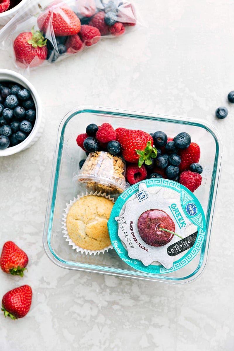 Yogurt parfait meal in a container, packed with yogurt, fresh fruit, and granola, ready to go.