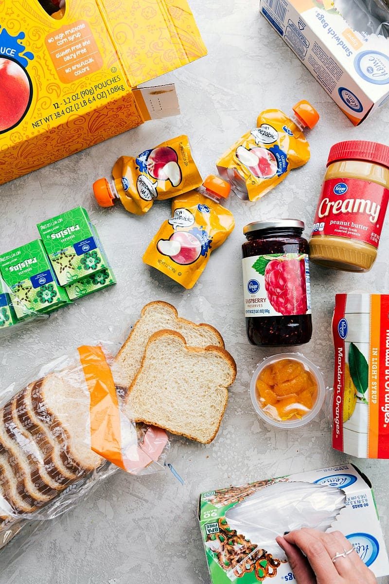 A variety of healthy ingredients laid out to prepare school lunches, including fresh fruits, vegetables, whole grains, and lean proteins.