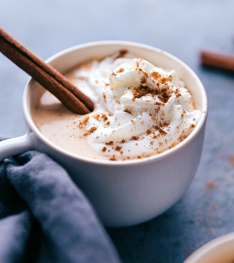Pumpkin spice latte steamer topped with whipped cream, pumpkin pie spice, and a cinnamon stick for the pumpkin spice desserts round-up.