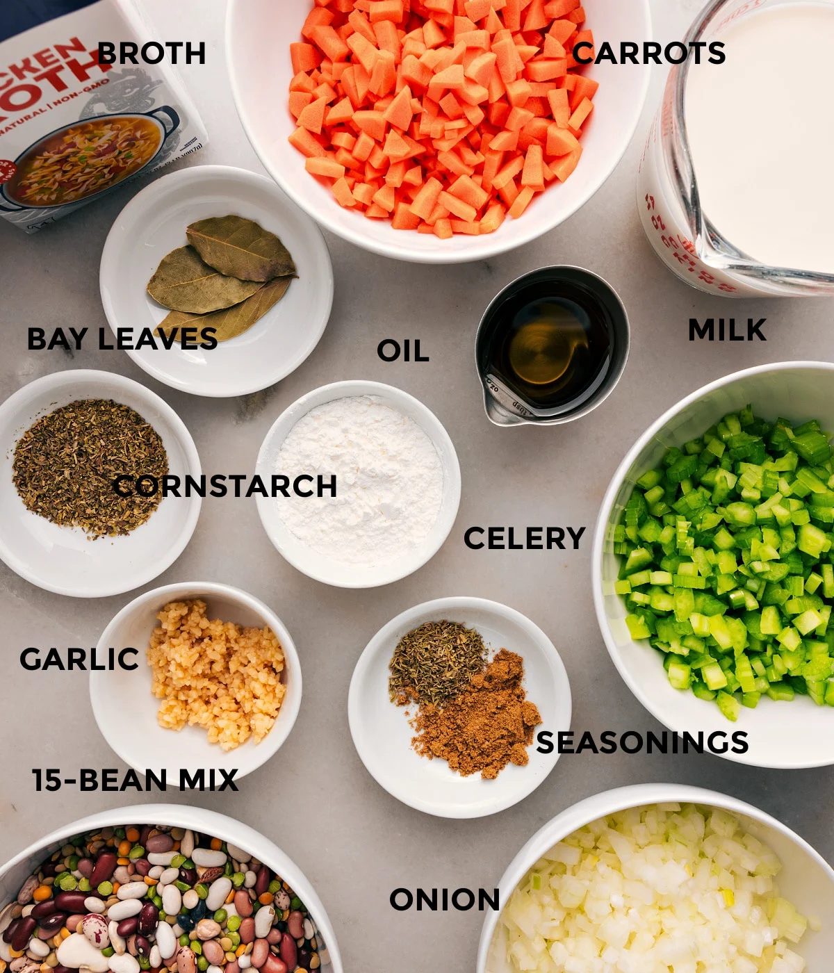 All the ingredients are prepped for straightforward assembly—veggies, milk, bay leaves, beans, garlic, cornstarch, seasonings, and broth.