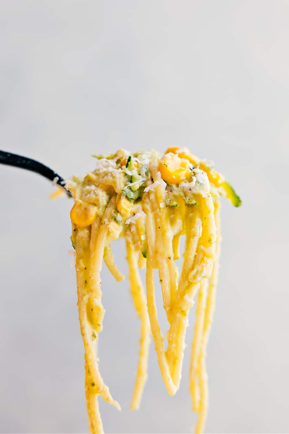 A forkful of the pasta being held up showing all the lively components to it.