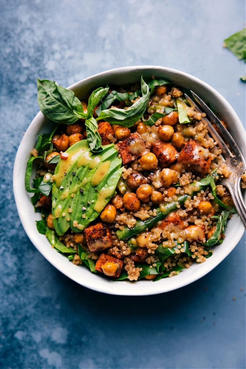 Vegetarian recipes: Nourish bowl topped with dressing, avocado, and basil.