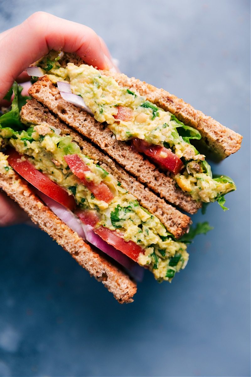 Garbanzo bean salad sandwich cut in half, showing the filling with tomatoes and onions.