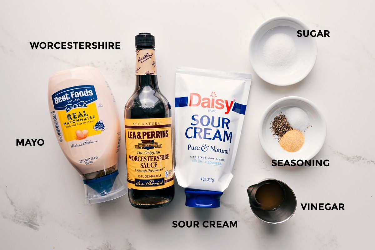 7 layer salad dressing ingredients set out for straightforward assembly including mayo, Worcestershire sauce, sour cream, vinegar, seasoning, and sugar.