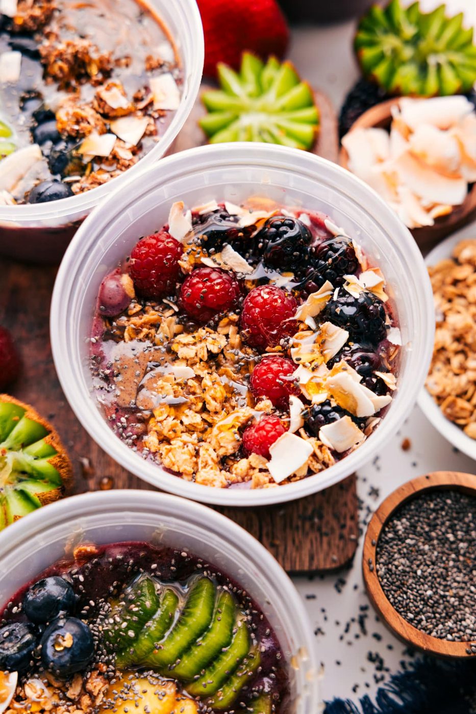 Berry version of this breakfast topped with granola, berries, chocolate flakes, chia seeds, and honey.