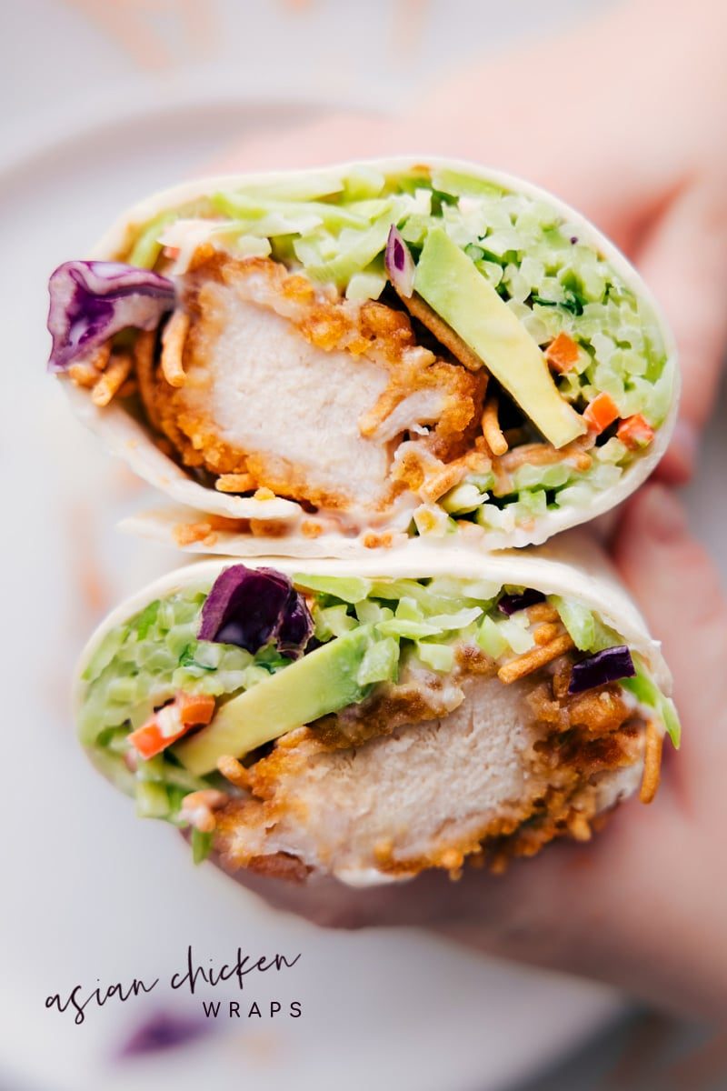 Asian Chicken Wraps cut in half and held up to show the satisfying crispy inside.