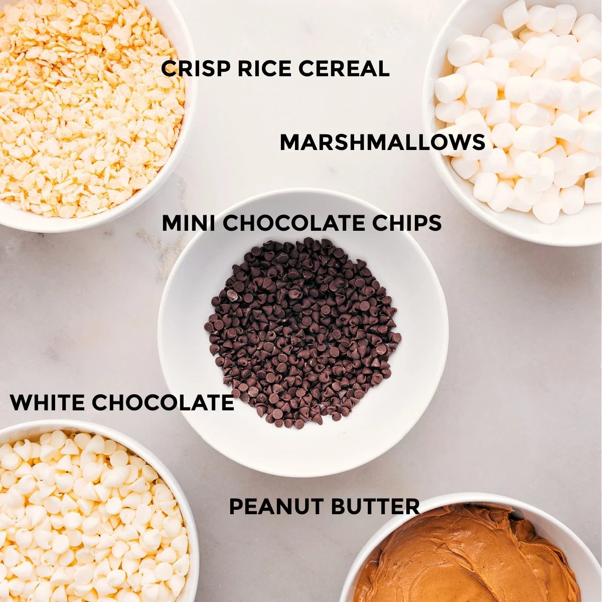 All the ingredients for this recipe are prepped and ready for straightforward assembly: marshmallows, chocolate chips, white chocolate, peanut butter, and Rice Krispie cereal.