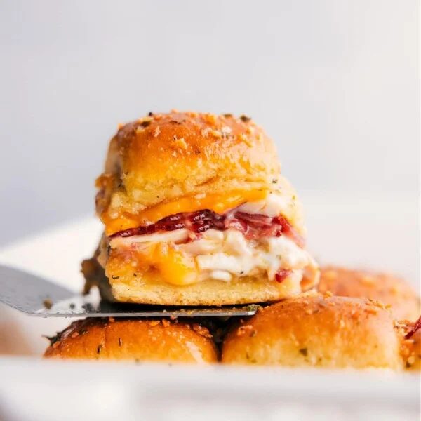 Stack of Chicken Bacon Ranch Sliders, with one sitting on a spatula.
