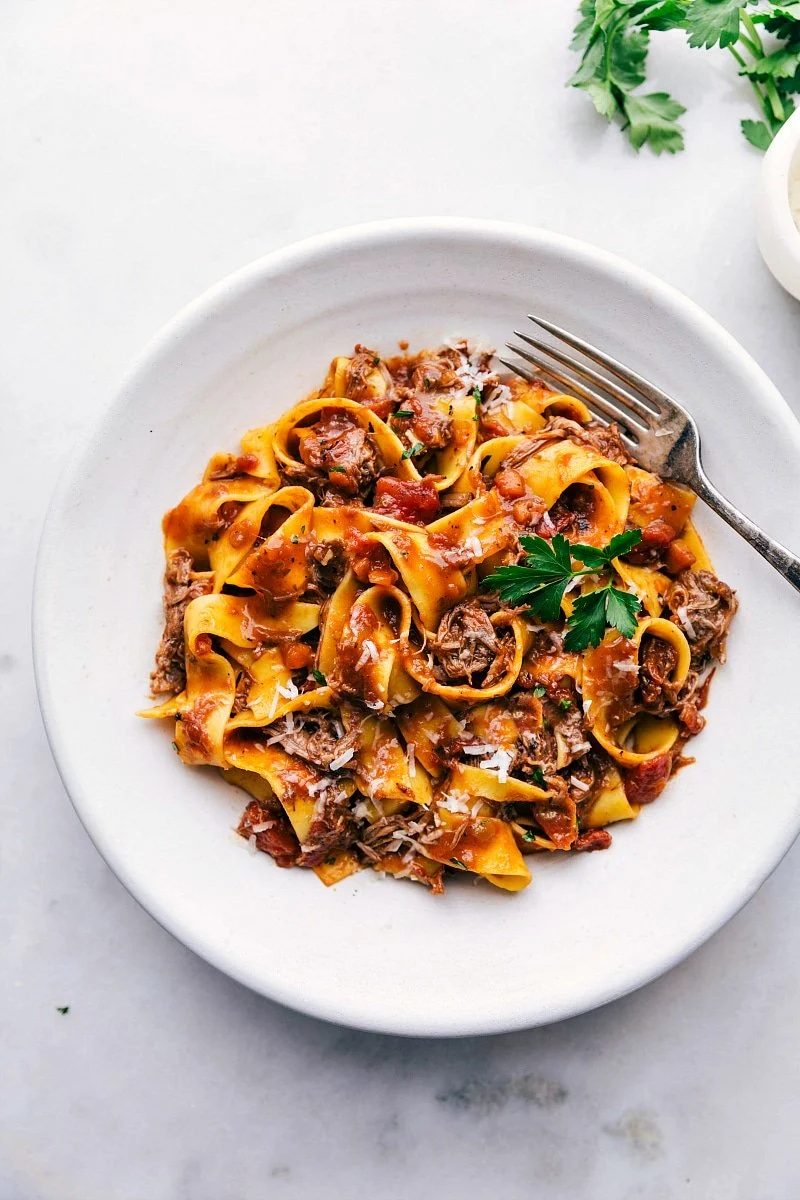 from-scratch slow cooker beef ragu tossed with pasta and topped with freshly shredded parmesan and parsley.