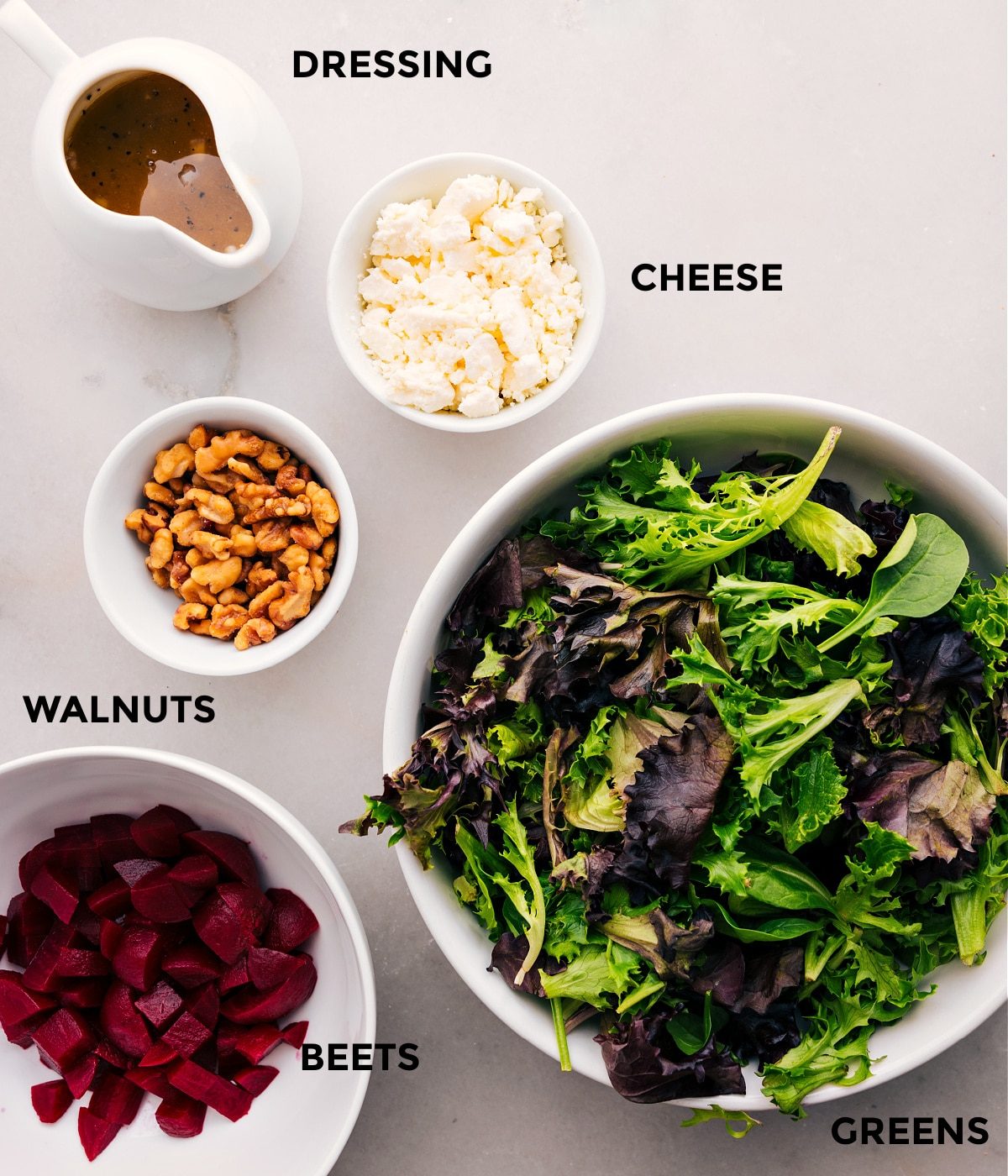 All the ingredients for this beet goat cheese walnut salad—greens, cheese, walnuts, and beets—are prepped and ready for straightforward assembly.