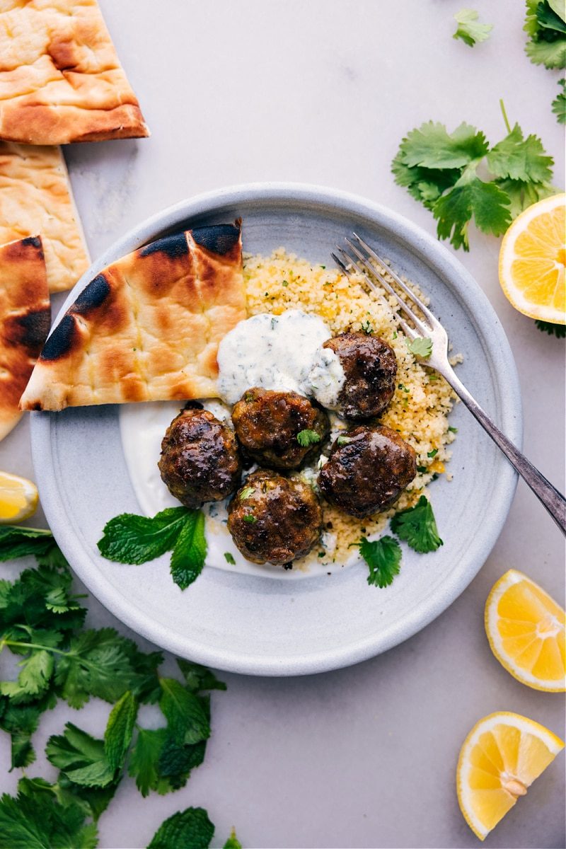Beef kofta meatballs served with vegetables and mint yogurt sauce.