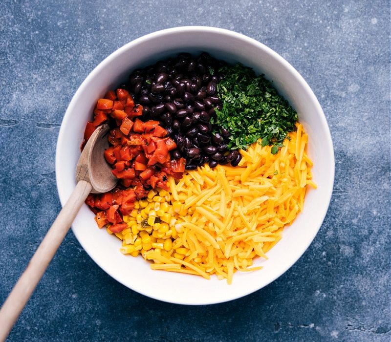 A bowl with roasted red peppers, black beans, corn, Cheddar and cilantro.