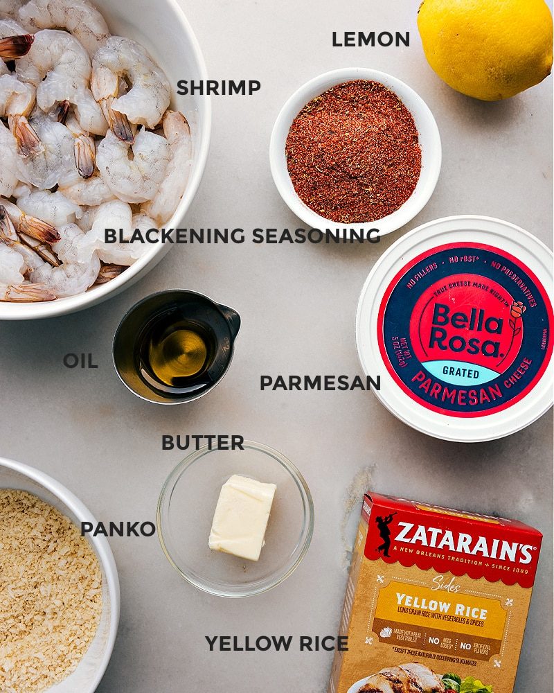 All the ingredients in this recipe prepped out for straightforward assembly including the shrimp, lemon, seasoning, parmesan, oil, butter, yellow rice, and panko.
