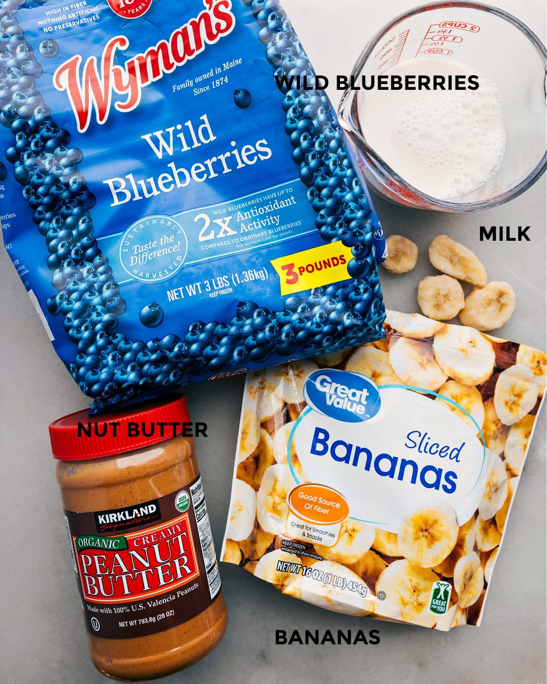 The four ingredients: frozen fruit, banana, almond milk, and nut butter prepped out for straightforward assembly.