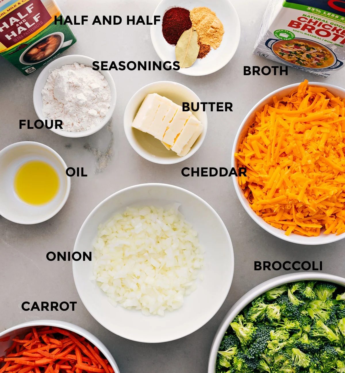 All ingredients prepped for straightforward assembly: seasonings, broth, butter, cheese, veggies, flour, oil, and half-and-half.