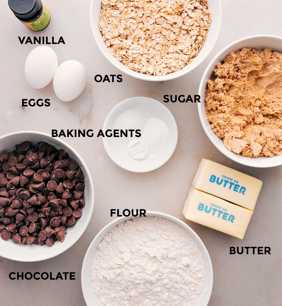 All the ingredients in this recipe—flour, chocolate, butter, sugar, oats, vanilla, eggs, and baking agents—are prepped and ready for straightforward assembly.