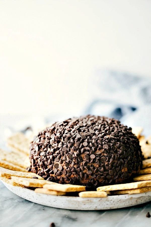 satisfying and gorgeous dessert cheesecake ball soft covered in chocolate chips with graham crackers on the side for dipping.