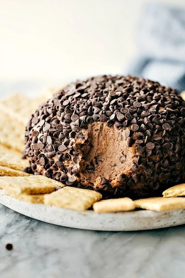 Simple and satisfying brownie 'batter' dessert cheese ball covered in chocolate chips with graham crackers surrounding it.