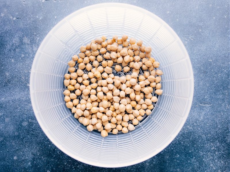 Overhead image of the chickpeas being drained and washed