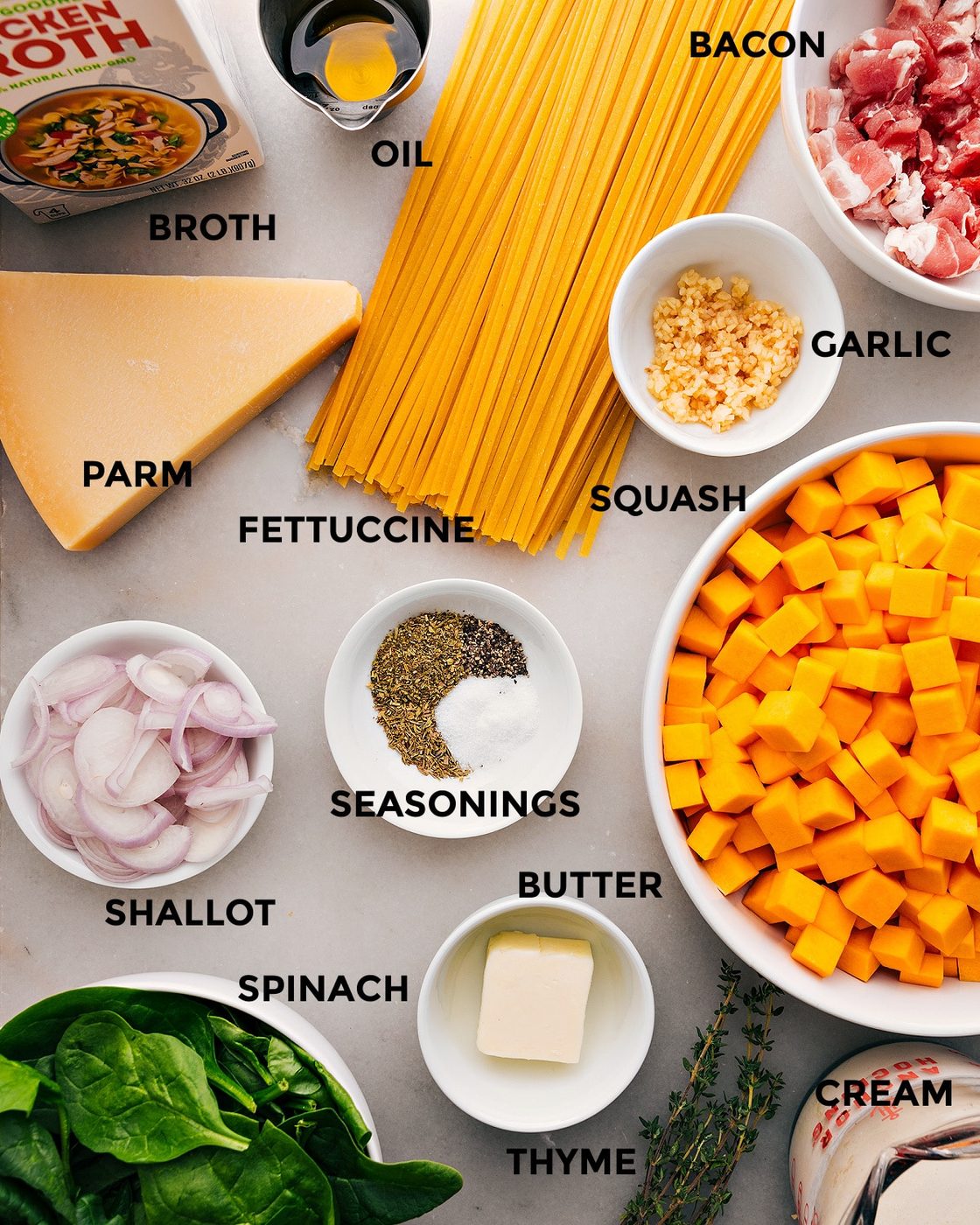 All the ingredients for this recipe are prepped and ready for straightforward assembly, including fettuccine, garlic, bacon, oil, broth, parmesan, shallots, butter, and veggies.