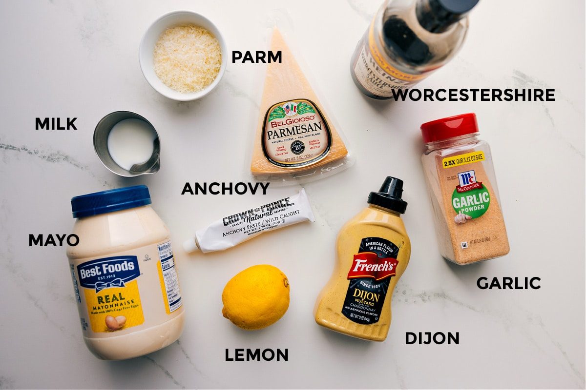 All the ingredients in this recipe prpped out for straightforward assembly including the parm, worcestershire, anchovy, lemon, dijon, garlic powder, milk, and mayo.