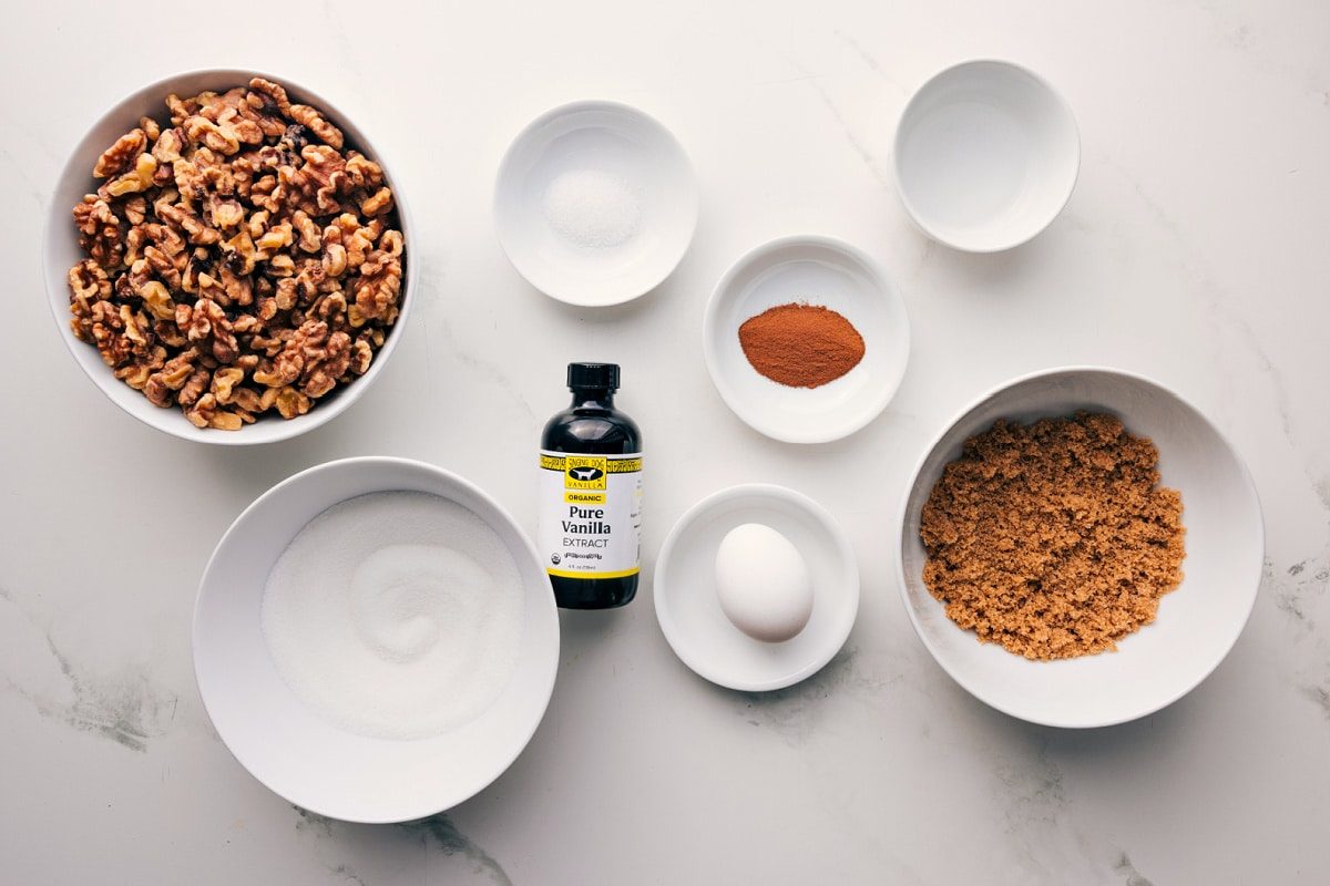 All the ingredients in this recipe prepped out for straightforward assembly including walnuts, sugar, eggs, vanilla, and cinnamon.