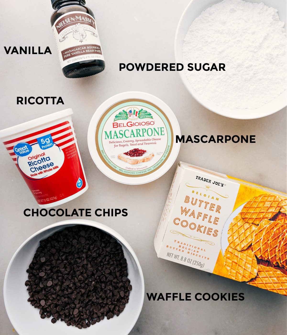 All the ingredients in this recipe including mascarpone, ricotta, powdered sugar, vanilla, and chocolate chips prepped out for straightforward assembly.