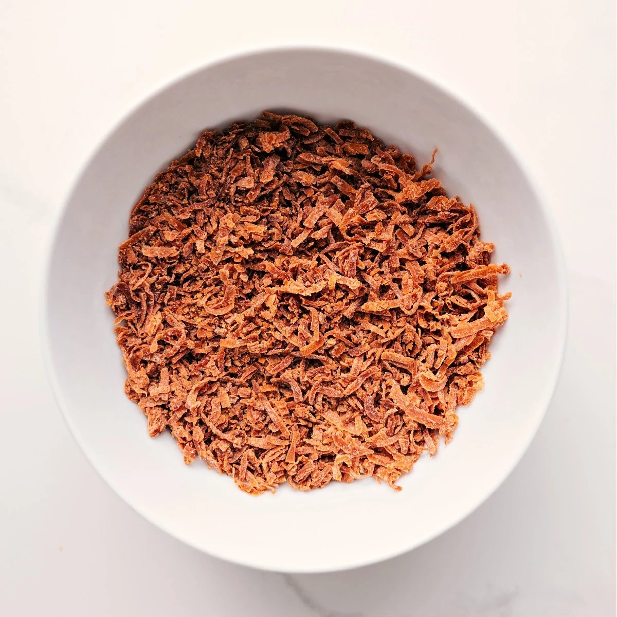 Toasted coconut prepared to sprinkle on top of this dessert.