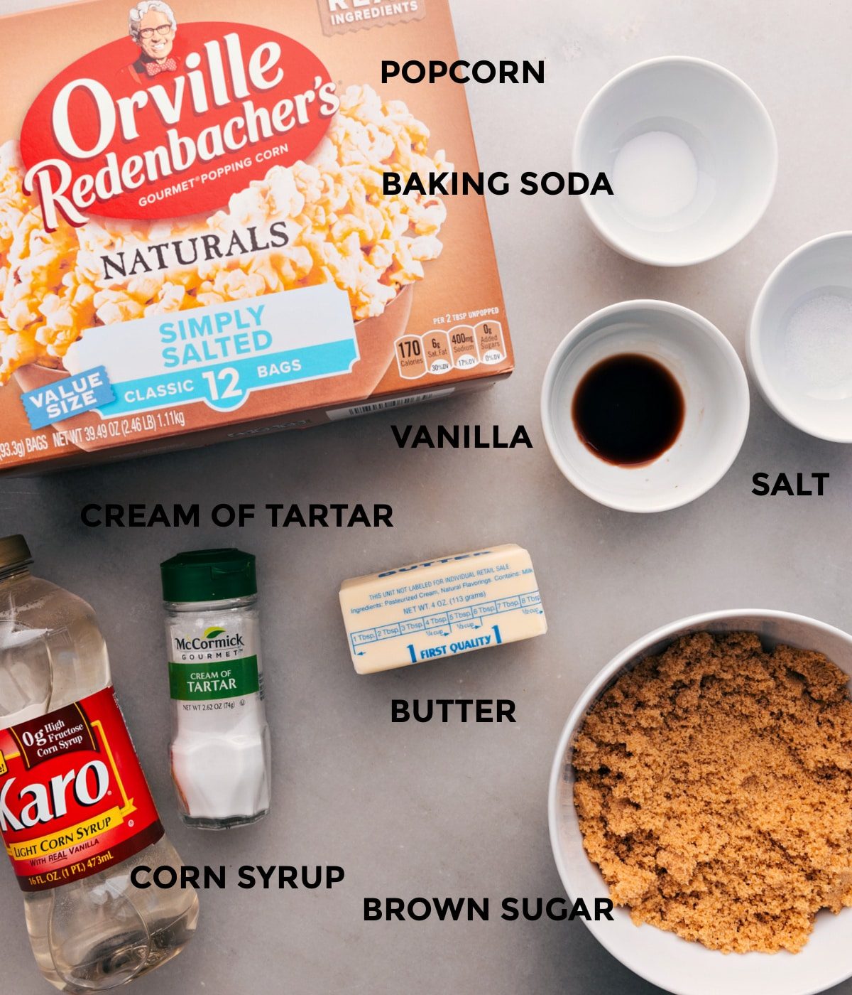 All the ingredients for this recipe are prepped for straightforward assembly: baking soda, salt, vanilla, butter, sugar, corn syrup, cream of tartar, and popcorn.