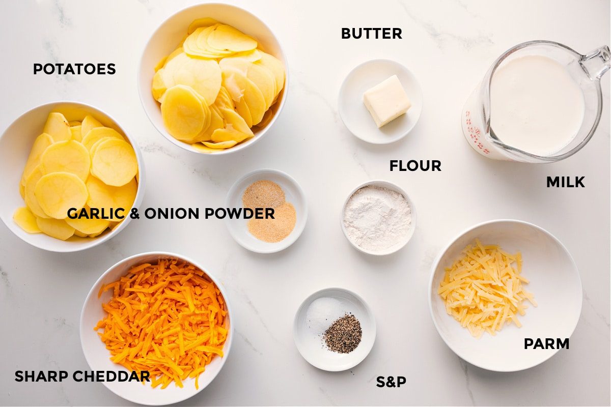 All the ingredients in this recipe prepped out for straightforward assembly including the potatoes, cheese, seasonings, flour, butter, parm, and milk.