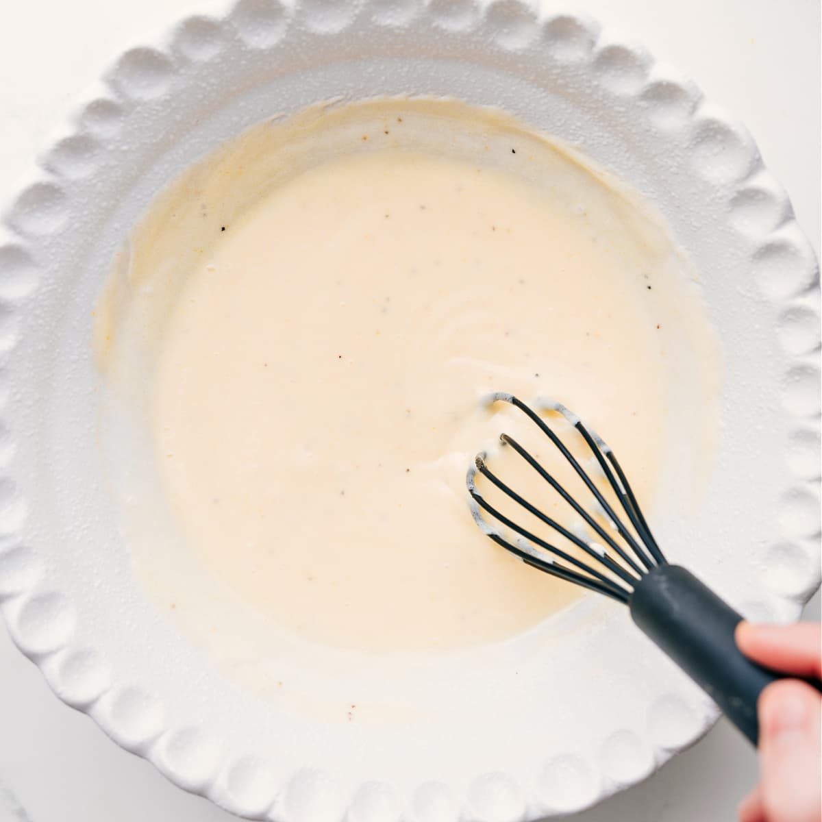 The Chick-Fil-A coleslaw dressing being whisked together in the bottom of a bowl.