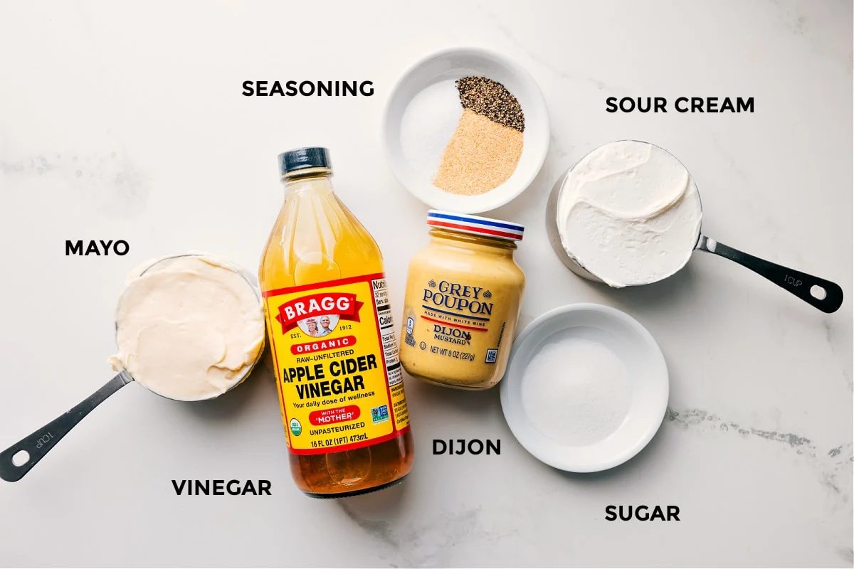 The dressing ingredients in this chicken macaroni salad prepped out for straightforward assembly including the mayo, vinegar, seasoning, sour cream, dijon, and sugar.