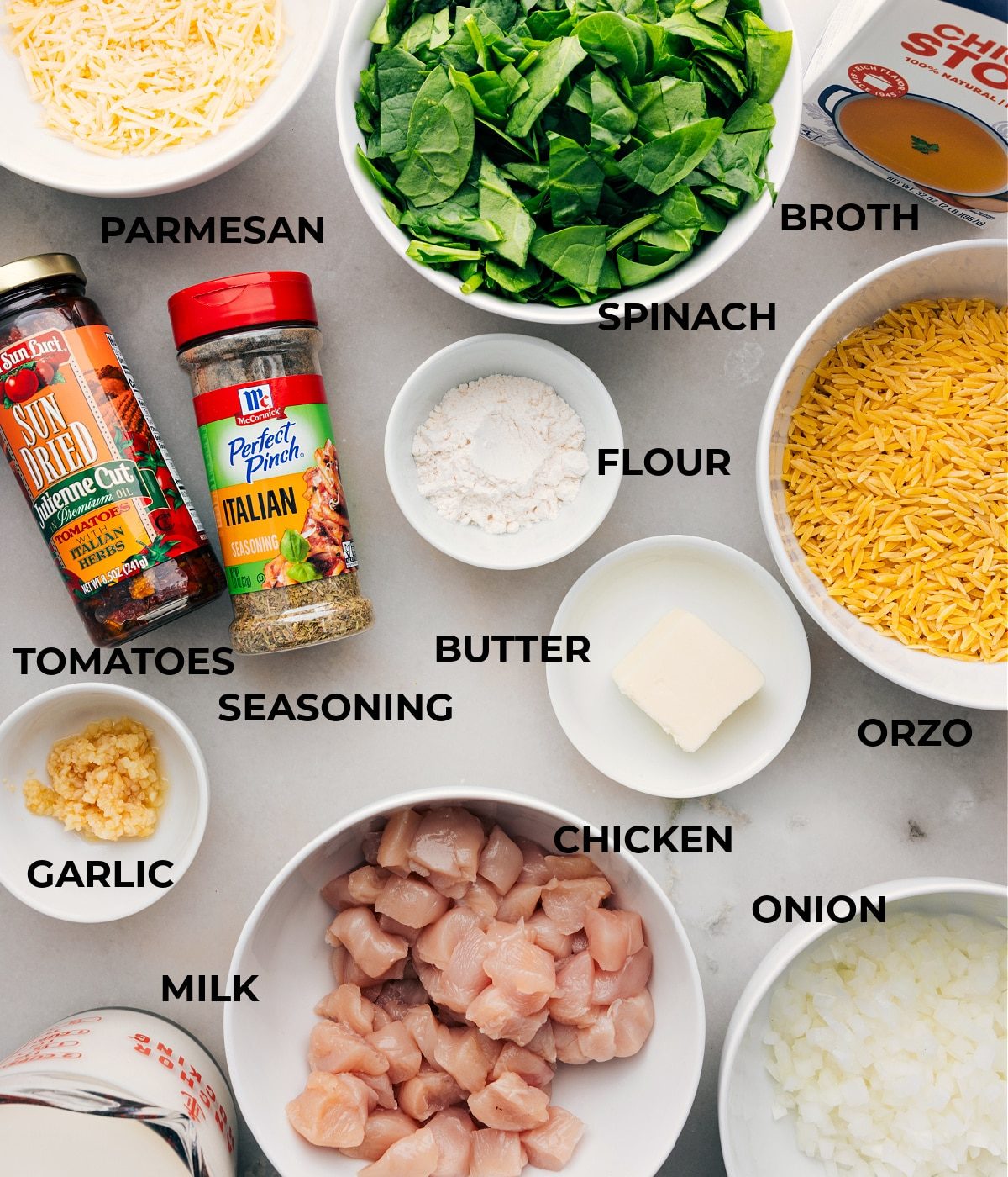 All the ingredients in this recipe are prepped for straightforward assembly, including spinach, broth, veggies, pasta, meat, seasonings, cheese, and milk.