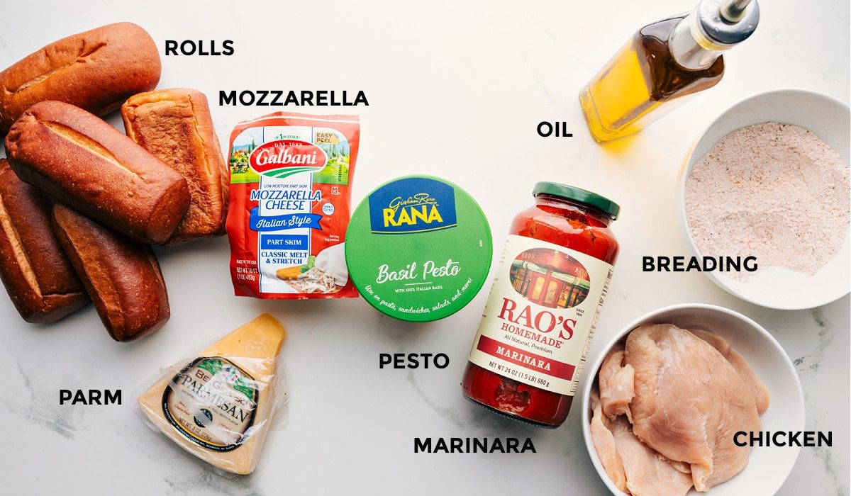 All the ingredients prepped and ready for straightforward assembly: rolls, mozzarella, parmesan, pesto, marinara, breading, oil, and chicken.