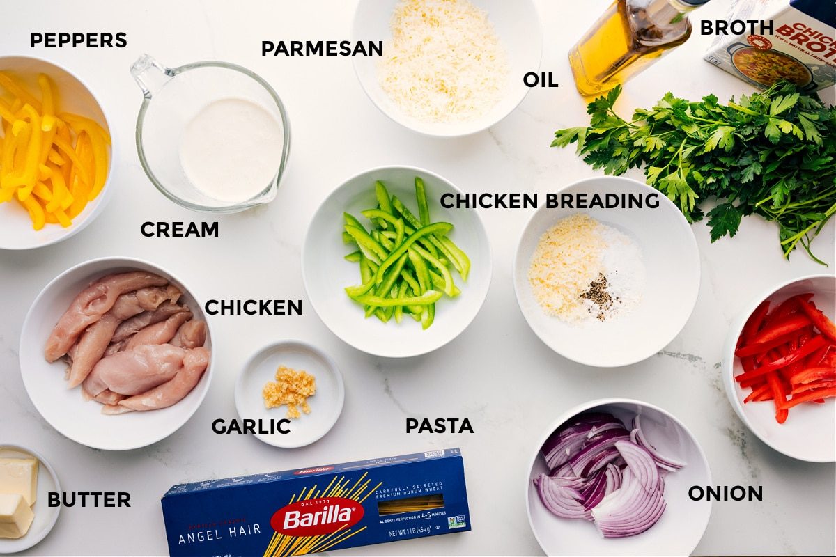 All Chicken Scampi ingredients prepped and ready for assembly: peppers, cream, chicken, butter, garlic, pasta, Parmesan, oil, onion, breading, broth, and parsley.
