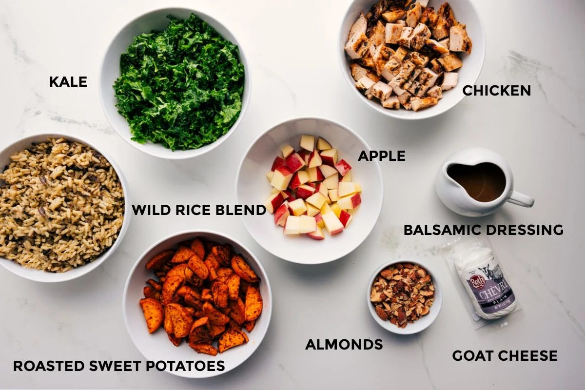 All the ingredients prepped out for straightforward assembly including the wild rice blend, kale, roasted sweet potatoes, apples, chicken, balsamic dressing, almonds, and goat cheese.