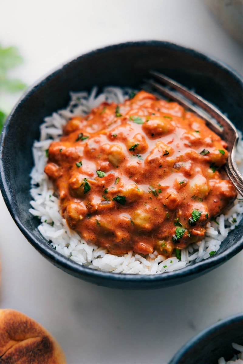 Butter chicken copycat with garbanzo beans instead of chicken, served over rice in a bowl.