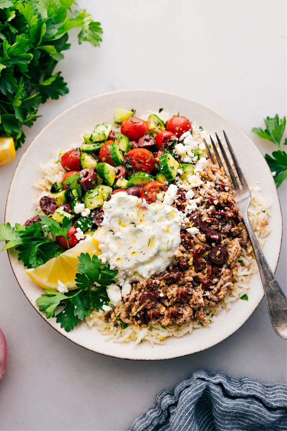 Chickpea recipes: Greek beef bowl over rice, topped with tzatziki and a cucumber tomato salad.
