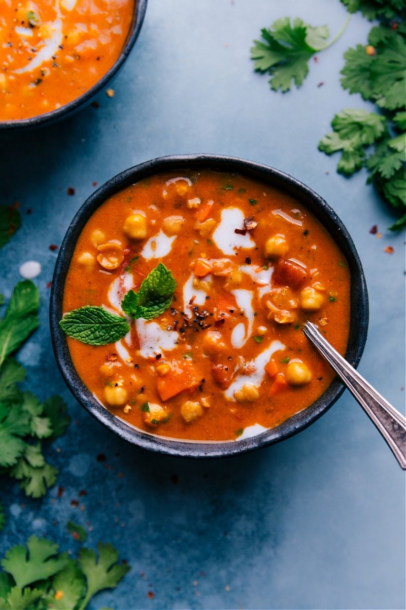 Vegan chickpea soup in a bowl, topped with fresh mint.
