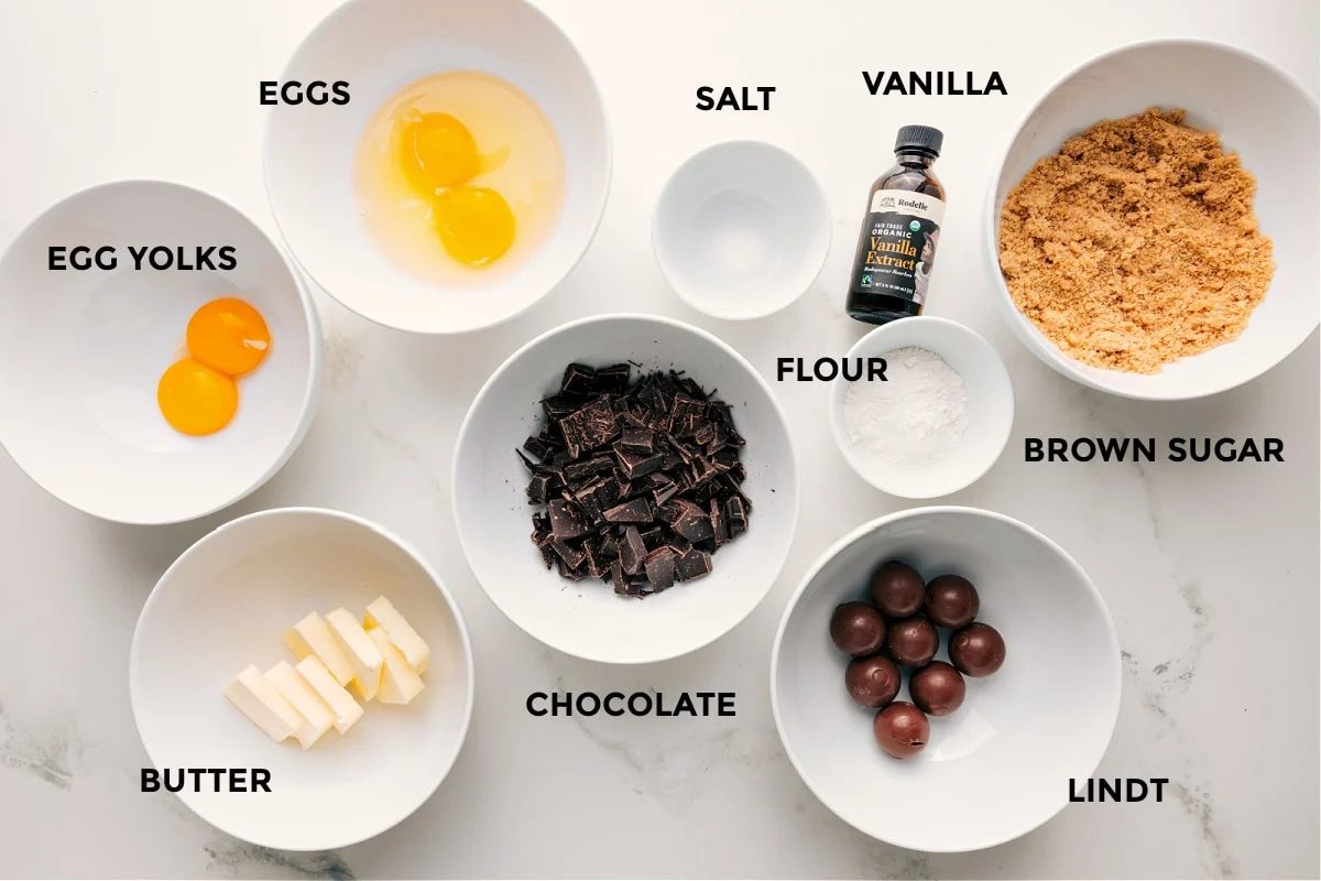 All the ingredients in this recipe prepped out for straightforward assembly including the egg yolks, butter, eggs, chocolate, salt, flour, vanilla, and brown sugar.