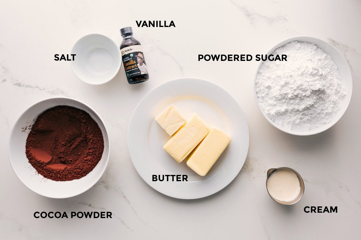 All the ingredients in this recipe prepped out for straightforward assembly including the cocoa powder, salt, vanilla, butter, powdered sugar, and cream.