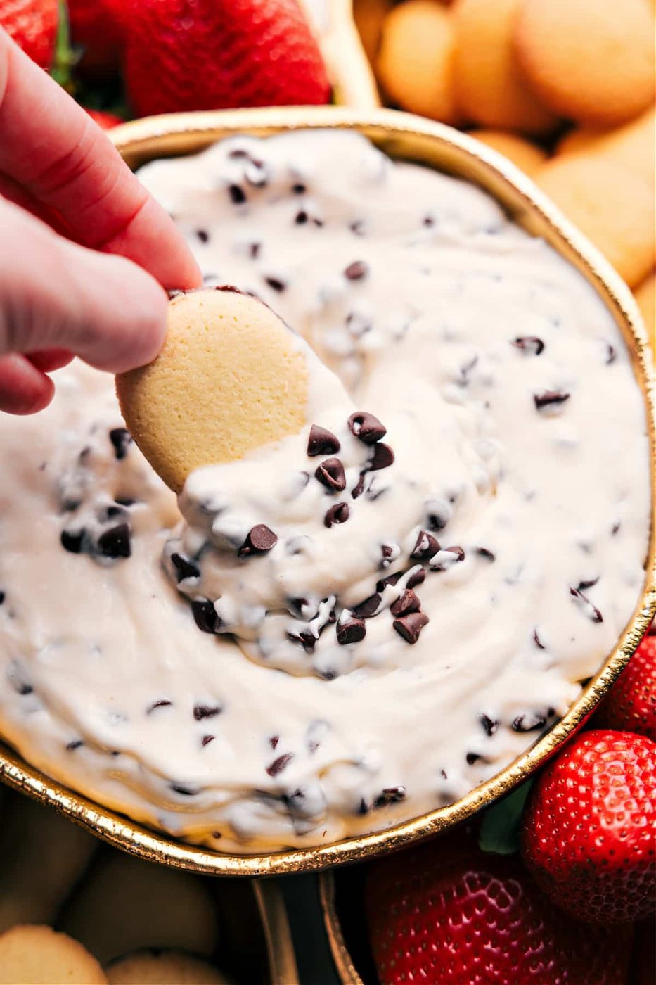 Chocolate chip dip with a cookie dipping in and extra chocolate chips on top.