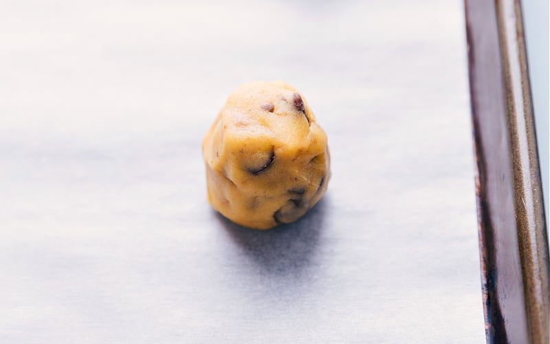 A cookie dough ball on the tray, ready to go in the oven.