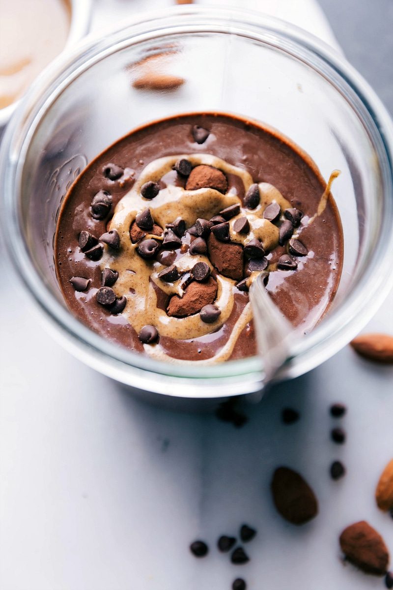 satisfying overnight oats made with chocolate almond milk, ready to eat, topped with a beautiful almond butter swirl and chocolate chips.