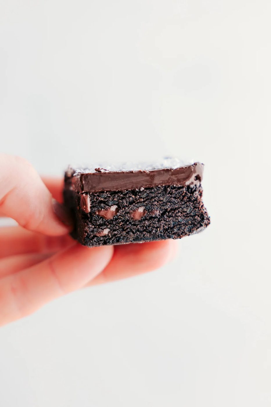 One of the date brownies being held up showing the satisfying insides.