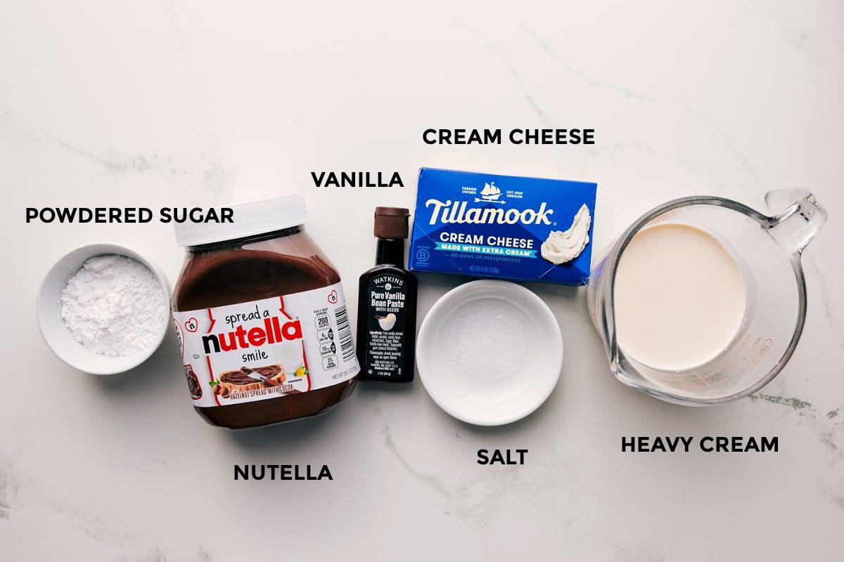 All the ingredients in this recipe prepped out for straightforward assembly including the powdered sugar, Nutella, vanilla, cream cheese, salt, and heavy cream.