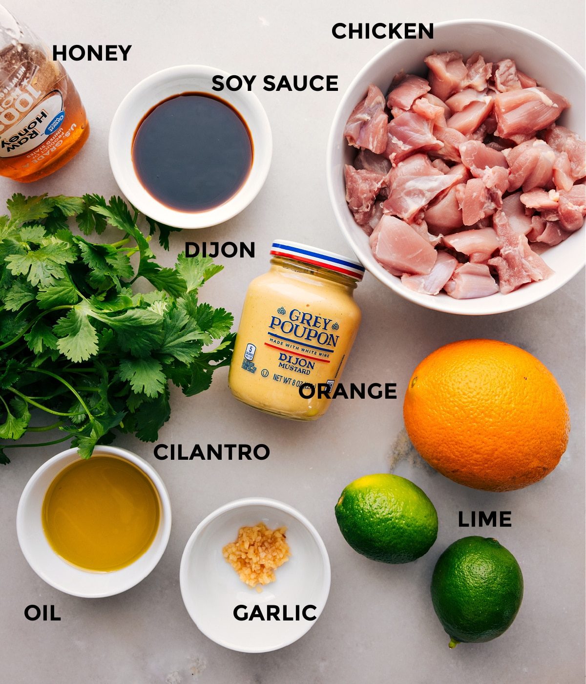 All the ingredients for this recipe are prepped and ready to go—including the meat, soy sauce, honey, Dijon, orange, cilantro, garlic, and lime—for straightforward assembly.