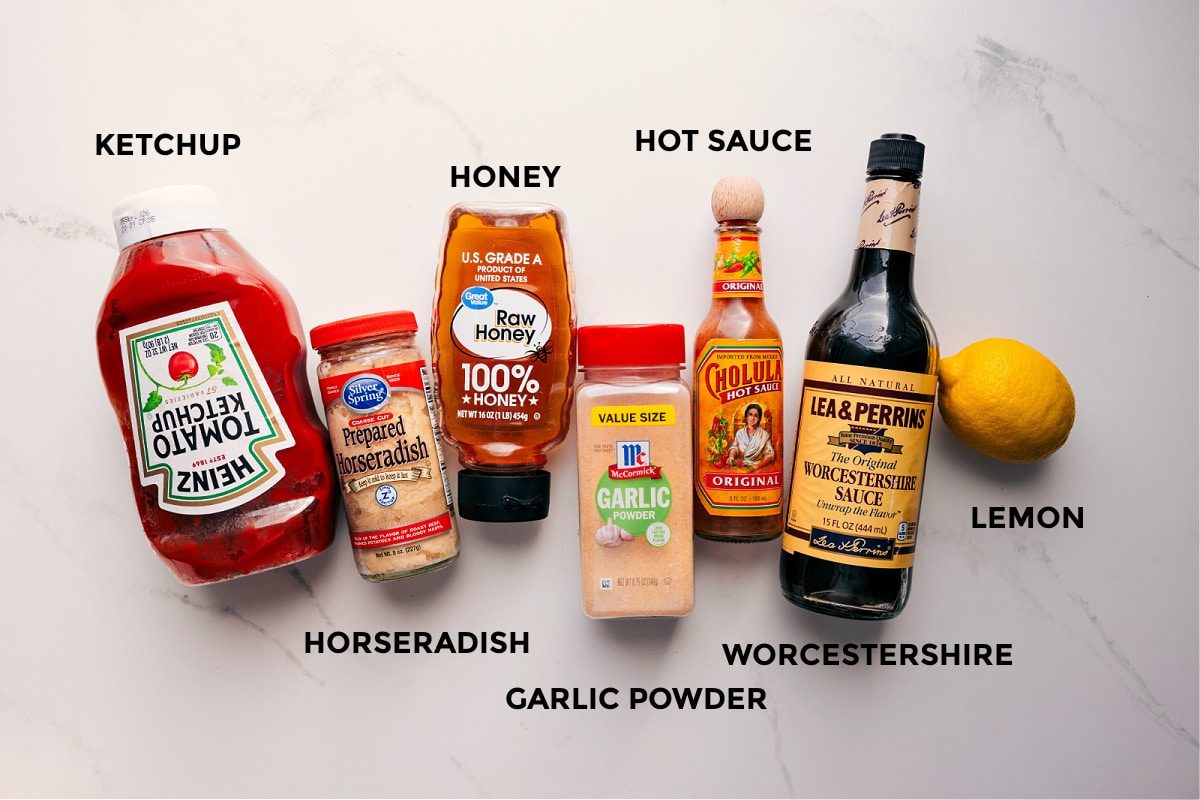 All the ingredients in this recipe prepped out for straightforward assembly including the ketchup, horseradish, honey, garlic powder, hot sauce, Worcestershire, and lemon.