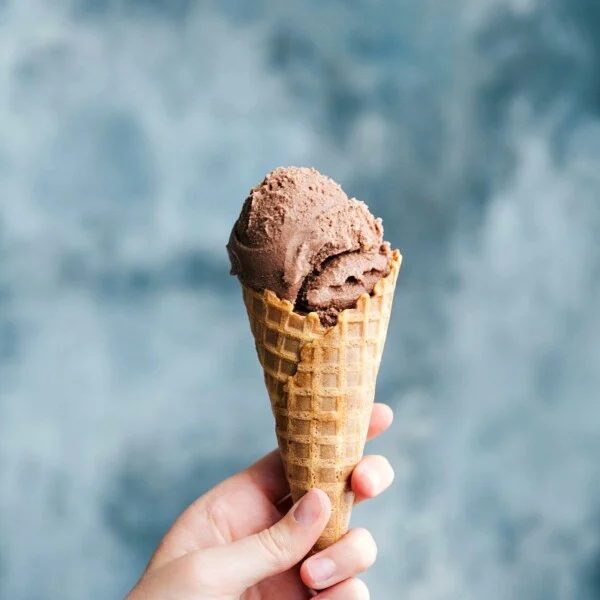 A waffle cone cone filled with rich and creamy chocolate gelato.