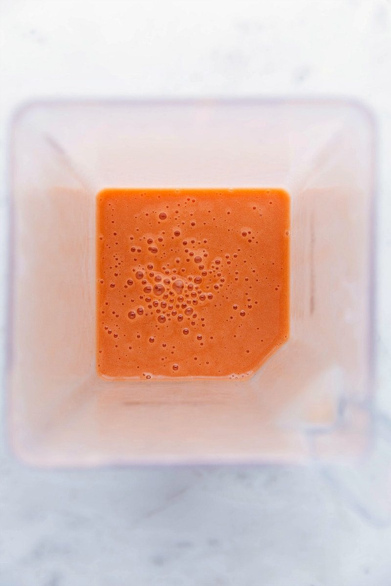 Smooth and creamy mango smoothie, evenly blended and still in the blender.